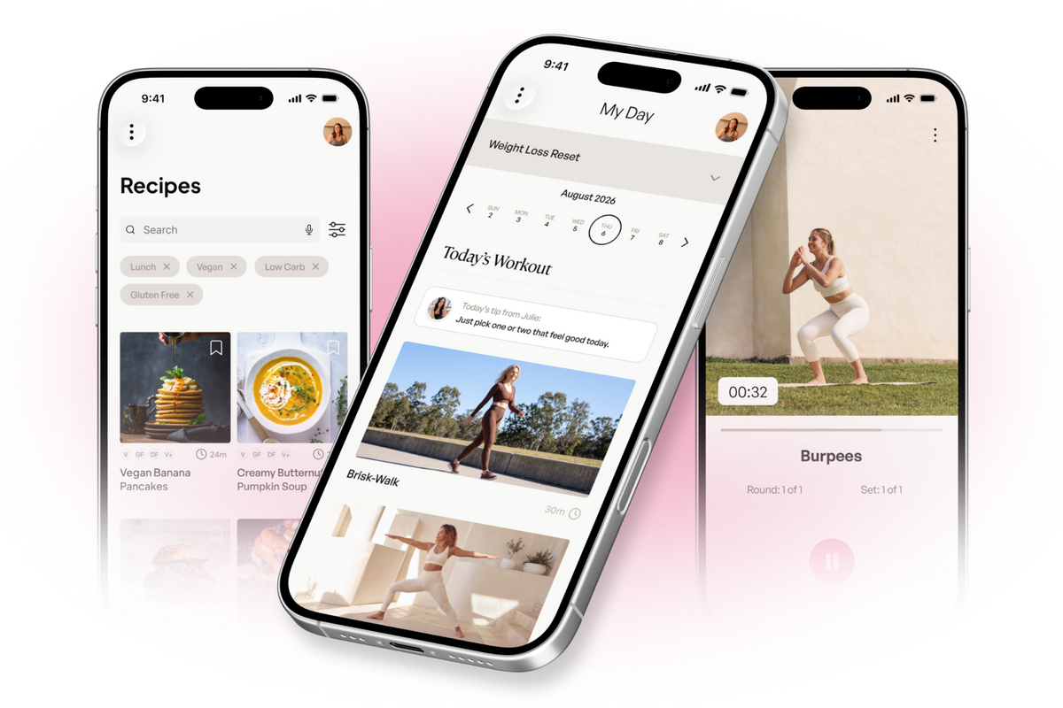 Three smartphones arranged in a fan shape on a white background, each displaying a fitness app interface. The center phone is largest and shows a daily workout log screen, while the left phone shows a recipes page and the right phone shows a workout video or exercise screen.